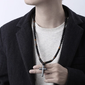 Mannelijk model met een kralenketting van tijgeroogstenen en een kruishanger