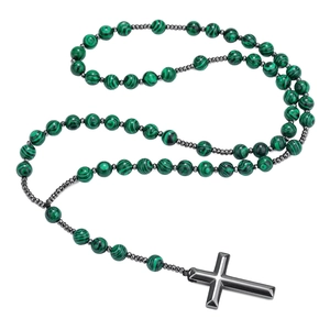 Detail van groen gestreepte stenen kralen en metalen kruishanger aan de herenketting