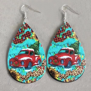 Detail of teardrop leather earrings featuring a vintage red truck and Christmas tree design