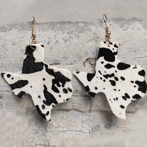 Western Texas map earrings with cowhide pattern and golden hooks on stone background