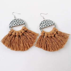 Detail of bohemian leopard print fan earrings with handmade woven brown cotton tassels