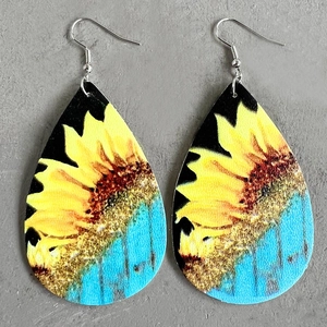 Detail of teardrop leather earrings featuring yellow sunflower print on a blue background