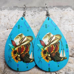 Dettaglio orecchini a goccia in pelle con stivali da cowboy e motivi in stile western