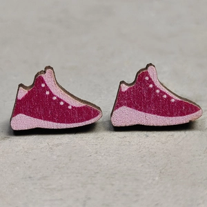 Close-up of pink wooden sneaker earrings with white polka dots and detailed wood grain texture