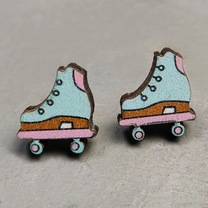 Macro detail of roller skate earrings featuring colorful printed wood on stone background
