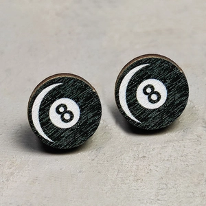 Macro shot of circular wood grain stud earrings featuring a black number eight billiards design