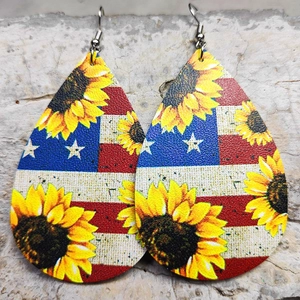 Dettaglio di orecchini a goccia in ecopelle con motivi bandiera USA e stampe di girasoli