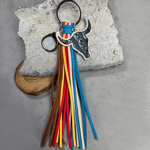 Detail eines Boho-Stierkopf-Schlüsselanhängers mit bunten Wildleder-Quasten und Strass