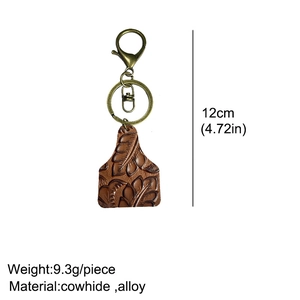 Detailed close-up of cowhide key chain with vintage embossed floral leaf patterns