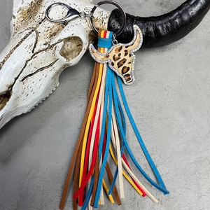 Detail of western bull head charm with rhinestones and multi-color fringe tassel