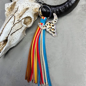 Detail of western bull head keychain featuring leopard print with colorful fringe