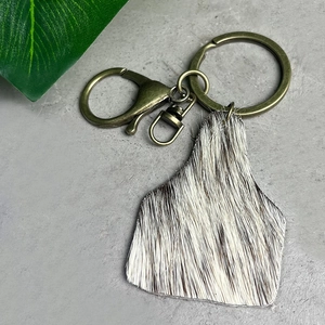 Western cowboy style leather keychain with black and white cowhide leopard print fur