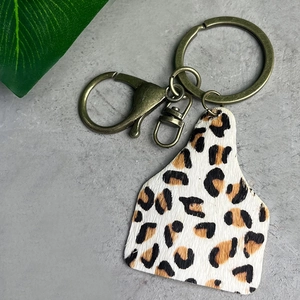 Detail of western leopard print cattle tag keychain with antique bronze metal hardware