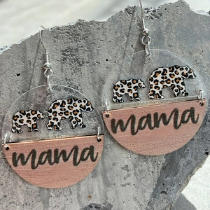 Acrylic leopard bear and wooden mama engraved dangle earrings on a natural stone surface