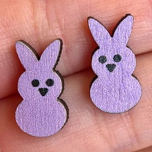 Macro shot of purple glitter bunny ear studs held in hand to show size and texture