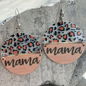 Leopard print acrylic and wood circle mama drop earrings on textured stone background