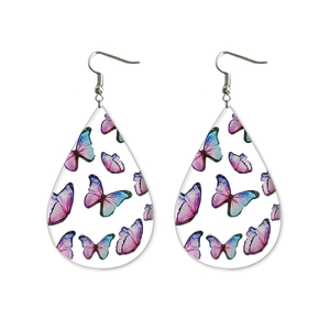 Close-up of teardrop acrylic earrings featuring vibrant purple and blue butterfly prints