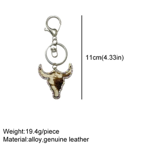 Detail of cow head keychain featuring genuine leather pattern and sparkling rhinestones