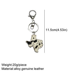 Detailed view of Texas map leather keychain with cow print pattern and alloy clip