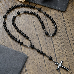 Detail of cross pendant necklace with black matte beads and tiger eye stones