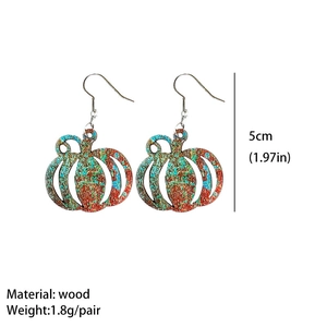 Detail view of hollow pumpkin earrings made of wood with colorful painted texture
