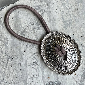 Élastique à cheveux bohème vintage avec breloque ovale en métal sur fond de pierre