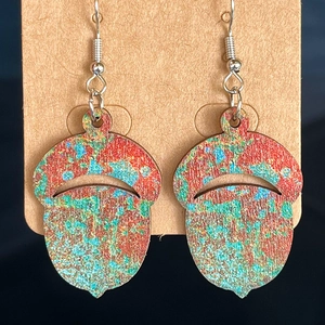 Macro shot of acorn-shaped drop earrings with colorful artistic painted wood texture
