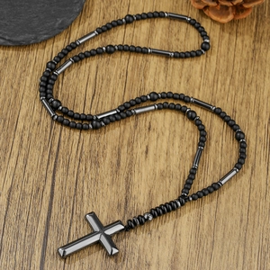 Detail van kruisketting met zwarte matte steenkralen en hematiet cilinders voor heren