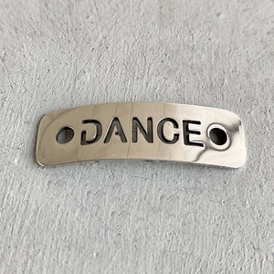 Polished silver metal shoelace charm with DANCE cutout design and dual attachment holes