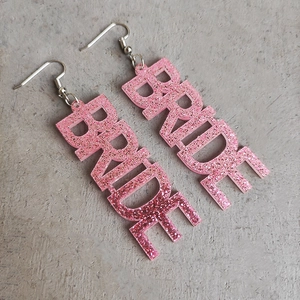 Detailansicht der BRIDE Buchstaben-Ohrringe mit rosa Glitzer-Acryl und langen Haken