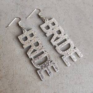 Detailaufnahme der silbernen Glitzer BRIDE Ohrringe für Hochzeiten und Brautpartys