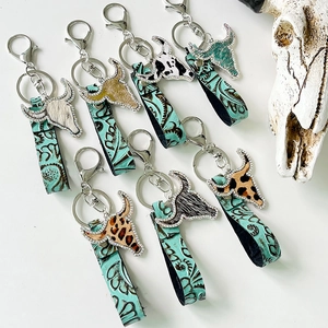 Detail of Western bull head keychains with rhinestone edges and ethnic embossed leather