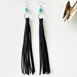 Detail of bohemian black leather fringe earrings with turquoise beads and silver ring