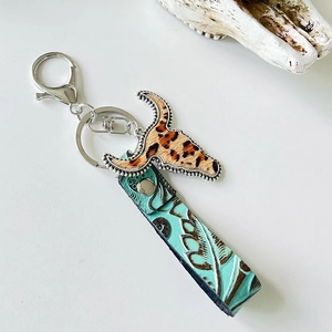 Western style leather keychain featuring bull head charm and embossed teal floral strap