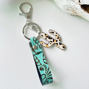 Detail of western leather keychain with embossed turquoise band and leopard print cactus