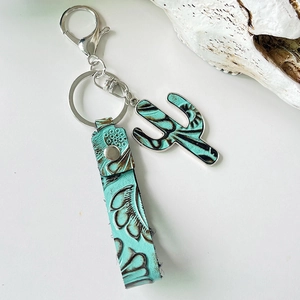Detail of western turquoise leather cactus keychain with vintage floral embossing
