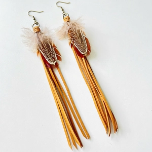 Detail of bohemian feather earrings featuring brown leather fringe and bronze metal hooks