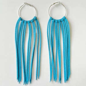 Detail view of vibrant blue tassel hoop earrings in a bohemian western fringe style
