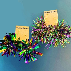 Detailed view of colorful tinsel fringe party earrings in blue and pink on display card