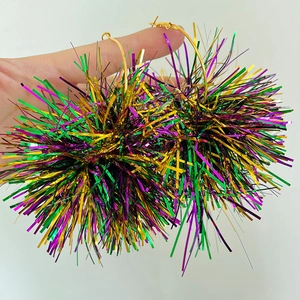 Close-up of purple, green, and gold tinsel ball earrings for Mardi Gras festivities