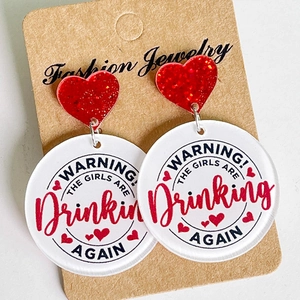 Detalle macro de pendientes de acrílico con frase Warning The Girls Are Drinking Again