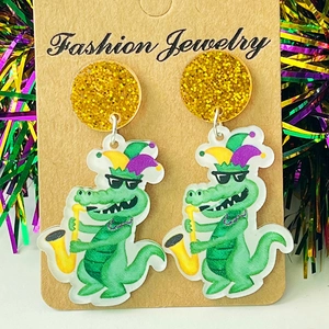 Detailopname van de Mardi Gras krokodil oorbellen met glitter en feestelijke confetti