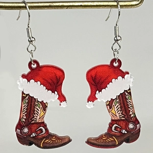 Detalle de pendientes navideños de acrílico con sombrero de Papá Noel y botas vaqueras