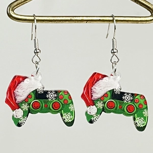 Detalle de pendientes de mando de videojuegos navideños con gorro de Papá Noel y nieve