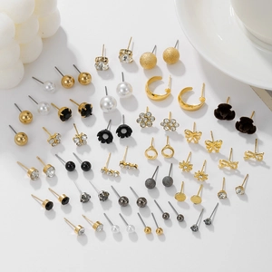 Close-up of assorted earring set with pearls, rhinestones, and geometric gold designs