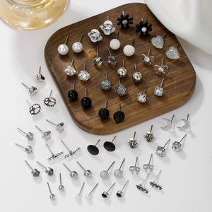 Detailed collection of pearl and crystal stud earrings on dark wood display board