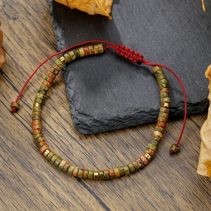 Detail of adjustable braided cord bracelet with natural stone beads and gold spacers