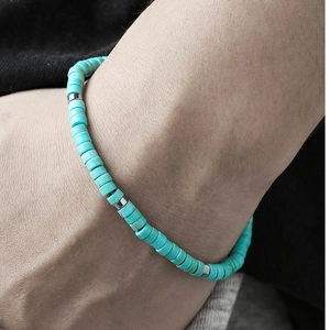 Detailed macro view of turquoise beaded bracelet with silver spacers on a woman's wrist