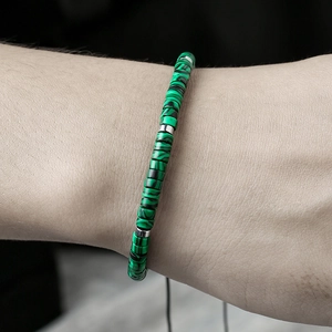 Detailed view of adjustable beaded bracelet with cylindrical malachite stones and silver spacers
