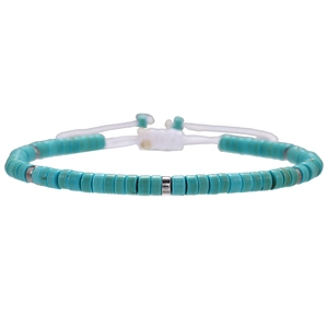 Detail of bohemian turquoise beaded bracelet with silver spacers and adjustable white cord